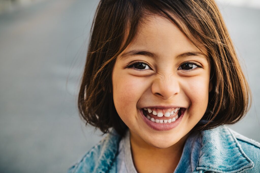 Happy young girl smiling, showcasing healthy teeth - Kids Smiles Pediatric Dentistry care.